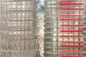 rij van boodschappen doen trolleys of karren in supermarkt. boodschappen doen mand. foto