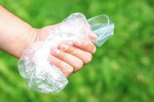 hand- houdt verfrommeld plastic puin foto