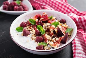 chia zaad pudding gemaakt met frambozen, vijgen en munt Aan donker achtergrond. de concept van mooi zo voeding. foto