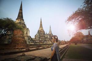 Aziatisch vrouw vervelend Thais traditioneel pak staand Bij oud tempel een van meest populair op reis bestemming in ayutthaya wereld erfgoed plaats van UNESCO centraal van Thailand foto