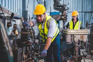 portret van zwaar industrie arbeiders werken Aan de metaal verzinsel werkwijze door in werking een draaibank Bij een machine voor staal structuur industrie. foto