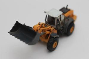 een dichtbij omhoog van miniatuur oranje wiel lader speelgoed- foto