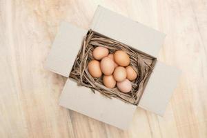 vers kip eieren in papier doos Aan de houten tafel foto