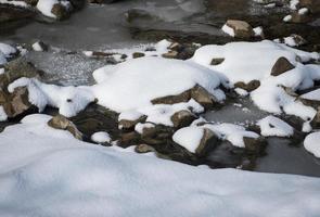 besneeuwde rotsen in de buurt van de rivier foto