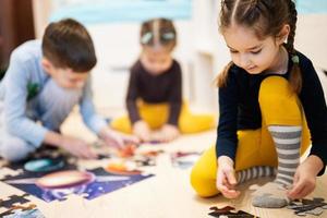 kinderen Verbinden decoupeerzaag puzzel stukken in een kinderen kamer Aan verdieping Bij huis. pret familie werkzaamheid vrije tijd. foto