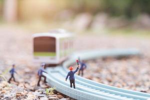 miniatuurspoorwegpersoneel dat bij een spoorweg werkt, reizen per treinconcept foto