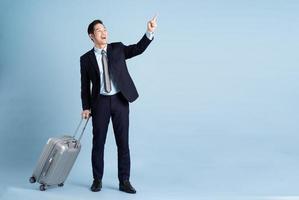 portret van Aziatisch zakenman vervelend een pak en trekken een koffer foto