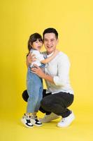 beeld van twee gelukkig vader en dochter spelen, geïsoleerd Aan geel achtergrond foto