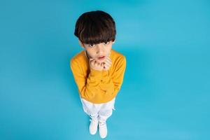 Aziatisch jongen portret poseren Aan blauw achtergrond foto