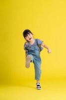 vol lichaam beeld van mooi Aziatisch baby meisje Aan geel achtergrond foto
