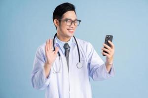 Aziatisch mannetje dokter portret Aan blauw achtergrond foto