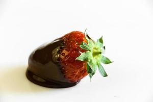 aardbeien met een staart gedrenkt in vloeibare chocolade foto