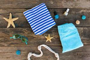 vrouwen zomer kleren en accessoires Aan oud houten achtergrond. top visie, vlak leggen. foto