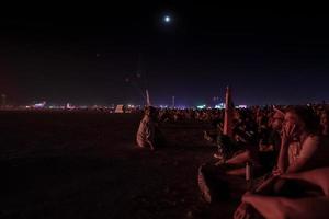 mensen wandelen naar zonsondergang Bij een festival in de woestijn Bij de brandend Mens festival. foto