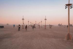 mensen wandelen naar zonsondergang Bij een festival in de woestijn Bij de brandend Mens festival. foto