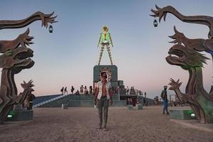 mensen wandelen naar zonsondergang Bij een festival in de woestijn Bij de brandend Mens festival. foto