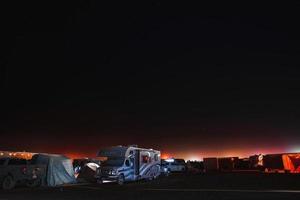 mensen wandelen naar zonsondergang Bij een festival in de woestijn Bij de brandend Mens festival. foto