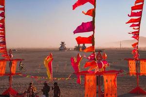 mensen wandelen naar zonsondergang Bij een festival in de woestijn Bij de brandend Mens festival. foto