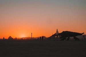 mensen wandelen naar zonsondergang Bij een festival in de woestijn Bij de brandend Mens festival. foto