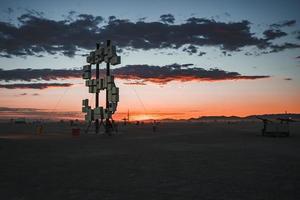 mensen wandelen naar zonsondergang Bij een festival in de woestijn Bij de brandend Mens festival. foto