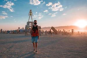 mensen wandelen naar zonsondergang Bij een festival in de woestijn Bij de brandend Mens festival. foto