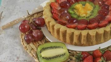 groot fruit taart met toppings van aardbeien, druiven, kiwi en ananas. hartig, zoet en vers. voedsel concept foto. foto
