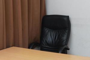 foto van een stoel en bureau met bruin venster gordijnen. werkruimte concept foto.