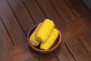 een dichtbij omhoog van maïs Aan de maïskolf geserveerd in een houten schaal. foto