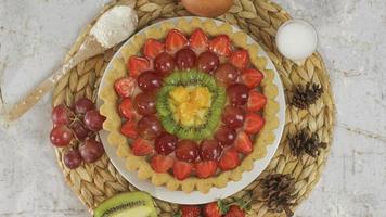 groot fruit taart met toppings van aardbeien, druiven, kiwi en ananas. hartig, zoet en vers. voedsel concept foto. foto