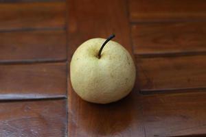 een dichtbij omhoog van Peer geïsoleerd natuurlijk patroon hout achtergrond. gezond voedsel concept foto. waterrijk fruit. foto