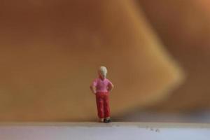 miniatuur figuur van een kind op zoek omhoog Bij de bergen gemaakt van een bord en sommige taarten. foto