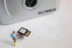 boef, Indonesië - dec, 19 2022. miniatuur figuur van een arbeider Holding een camera geheugen. foto