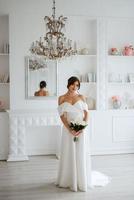 brunette bruid in een strak bruiloft jurk in een helder studio foto