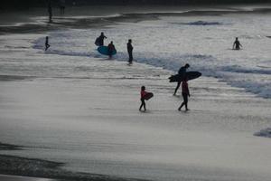 jong atleten beoefenen de water sport van surfing foto