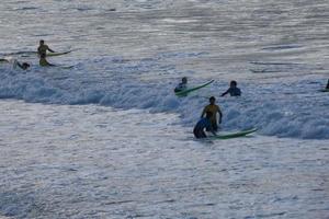 jong atleten beoefenen de water sport van surfing foto