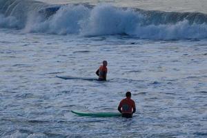 jong atleten beoefenen de water sport van surfing foto