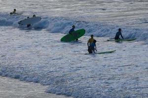 jong atleten beoefenen de water sport van surfing foto