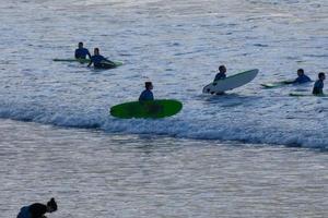 jong atleten beoefenen de water sport van surfing foto