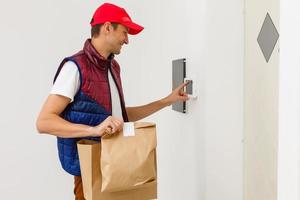 jong knap Mens leveren voedsel in een appartement foto