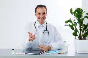 jong mannetje dokter met tablet in kantoor foto