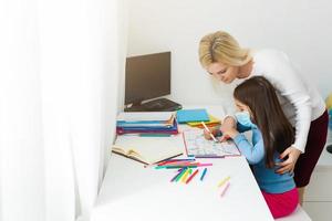 moeder en dochter in beschermend masker Doen huiswerk Bij afstand huis scholing, quarantaine foto