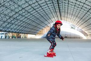 weinig meisje Aan rol skates in stad in voorjaar foto