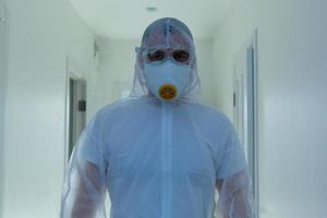 wetenschapper in beschermend dragen, bril en gasmasker foto