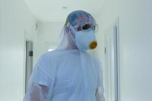 wetenschapper in beschermend dragen, bril en gasmasker foto