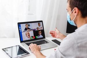 blij vriendelijk jong leraar met een gelukkig stralend glimlach zittend werk Aan klasse aantekeningen in voorkant van een groen schoolbord foto