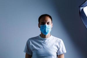 sterk Mens vervelend masker naar voorkomen griep virus en stof lucht verontreiniging Aan wit achtergrond foto