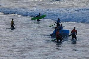 jong atleten beoefenen de water sport van surfing foto