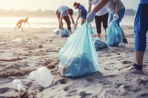 een groep van onherkenbaar mensen verzamelen vuilnis van de strand in blauw Tassen voor de probleem van plastic verontreiniging in de milieu foto