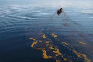 olie lekken van schip , olie morsen verontreiniging vervuild water oppervlak. water verontreiniging net zo een resultaat van menselijk activiteiten foto