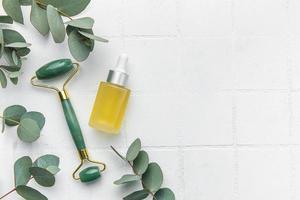 spa behandeling concept. natuurlijk spa schoonheidsmiddelen producten met eucalyptus olie, massage jade rol, eucalyptus blad. foto